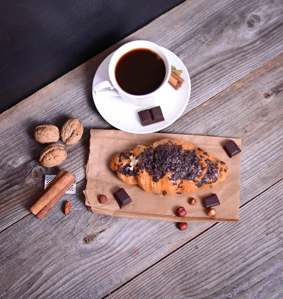 Croissant al cioccolato con caffè su fondo di legno — Foto Stock