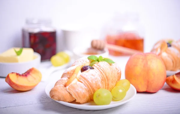 Fresh fruit croissant on white wooden background — Stock Photo, Image