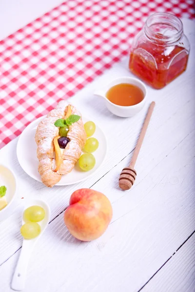 Fresh fruit croissant with peach and jam for breakfast on white — Stock Photo, Image
