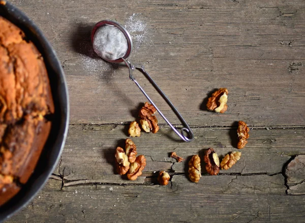 Čerstvé vlašské ořechy a prášek cukru na dřevěný stůl — Stock fotografie