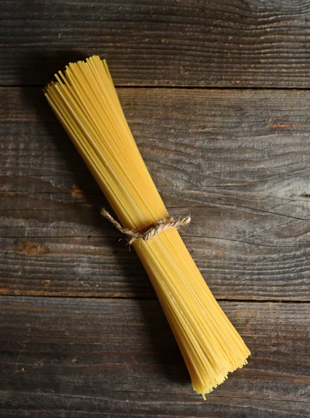 Bunch of spaghetti on wooden table background with copy space — Stock Photo, Image