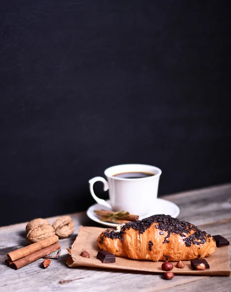 Croissant au chocolat avec café sur table rustique — Photo
