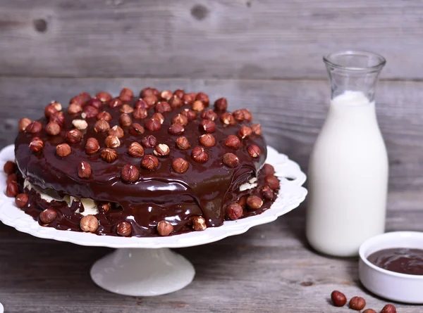 Leckere Schokoladenkuchen mit Haselnüssen auf dem Tisch und dunkler Schokolade — Stockfoto