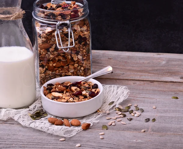 Granola δημητριακά με μπουκάλι γάλα στο ξύλινο τραπέζι — Φωτογραφία Αρχείου