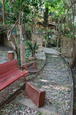 Bankta ve eski bavullar rayların arkasında.