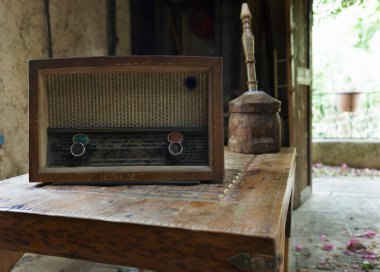 Tahta masadaki tozlu eski radyo.