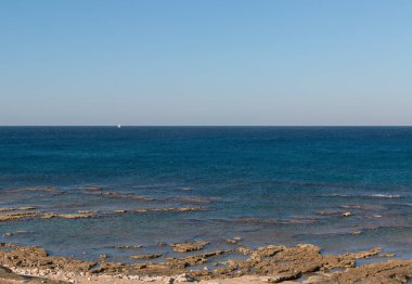 Plaj ve beyaz yelkenli ufukta