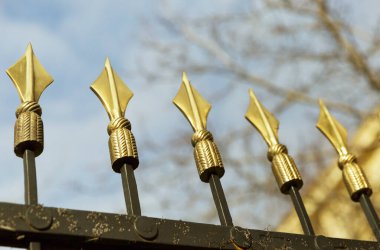 Arkaplanda altın mızraklar var.