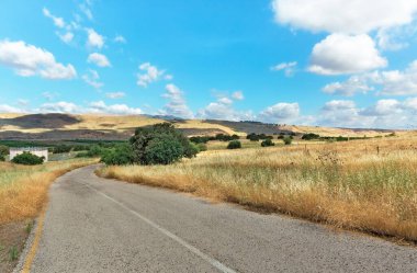 Golan Tepeleri 'ndeki yol güzel bulutların arka planına karşı. İsrail