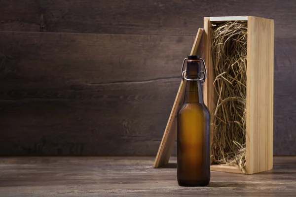 Craft beer bottle with a wooden gift box on a rustic table — Stock Photo, Image