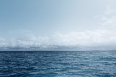 View of a lake with blue water with flying clouds