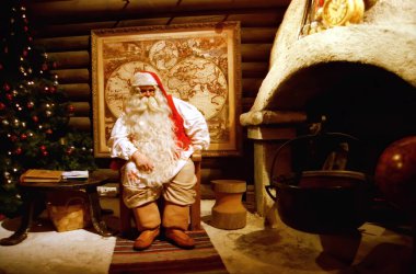Rovaniemi Finlandiya 25 Temmuz 2000: Noel Baba ofisinde şöminenin yanında oturuyor, yeni yıl ve noel kavramları