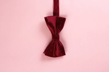 Pembe arkaplanda kırmızı papyon, seçici odak, kopyalama alanı