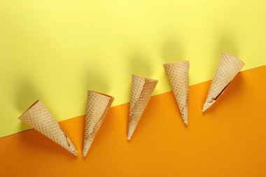 Sarı arka planda Emty Dondurma kalıpları. En iyi manzara. Boş waffle dondurma külahları.