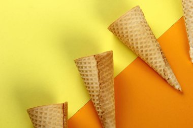 Sarı arka planda Emty Dondurma kalıpları. En iyi manzara. Boş waffle dondurma külahları.