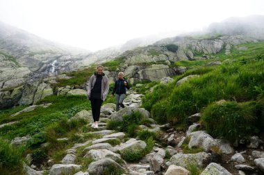 HIGH TATRA, SLOVAKIA - 20 Temmuz 2019: Hrebienok, Stary Smokovec, Vysoke Tatry. Yüksek Tatra dağlarının zirvesine tırmanan insanlar, Slovakya                               