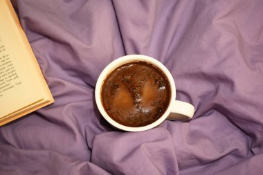 Yatak örtüsünün arkasında kahve fincanı var. Aşk ve Sevgililer Günü kavramı 