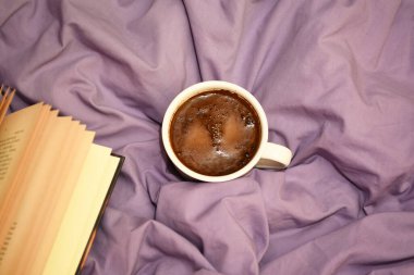 Yatak örtüsünün arkasında kahve fincanı var. Aşk ve Sevgililer Günü kavramı 