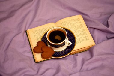 Yatak örtüsünün arkasında kahve fincanı var. Aşk ve Sevgililer Günü kavramı 