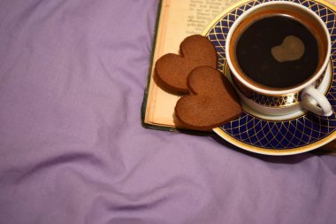 Yatak örtüsünün arkasında kahve fincanı var. Aşk ve Sevgililer Günü kavramı 