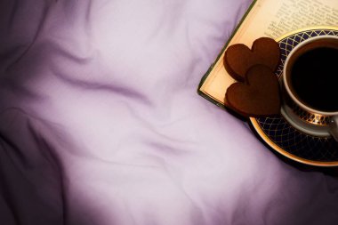 Yatak örtüsünün arkasında kahve fincanı var. Aşk ve Sevgililer Günü kavramı 