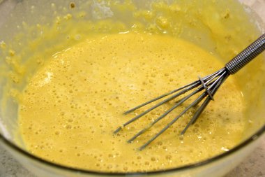 Sarı hamurlu ve köpüklü kaşık, mürver çiçekli krep.