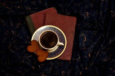 Kahve fincanı ve gece mavisi arka planda iki zencefilli ekmek ocağı. Aşk ve Sevgililer Günü kavramı