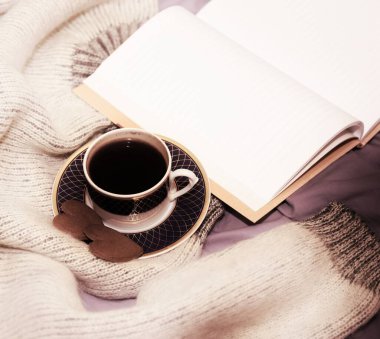 Bir fincan kahve, iki zencefilli kek kalbi ve yatağın üzerinde boş bir defter. seçici odak, kopyalama alanı, yumuşak bulanıklık etkisi