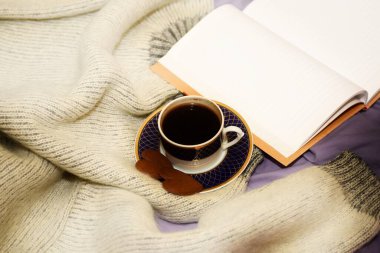 Bir fincan kahve, iki zencefilli kek kalbi ve yatağın üzerinde boş bir defter. seçici odak, kopyalama alanı, yumuşak bulanıklık etkisi
