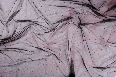 Pembe arka planda küçük yıldızlar olan buruşuk siyah şeffaf kumaş. Koyu Kumaş arkaplanı 
