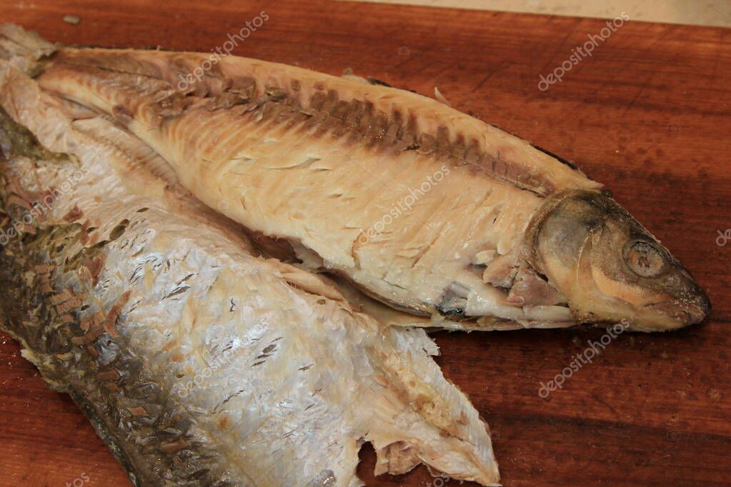 Pescado entero en sal cocido con la piel quitada por un lado.Pescado