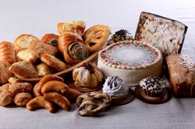 İçinde bir sürü kek, kek ve turta olan bir masa. Beyaz kumaşlarda pasta seçimi. Boşluğu kopyala 