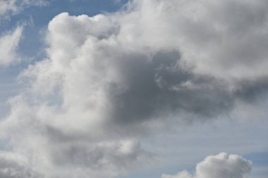 Mavi gökyüzü arka planında siyah beyaz bulutlar, bulut arkaplanı