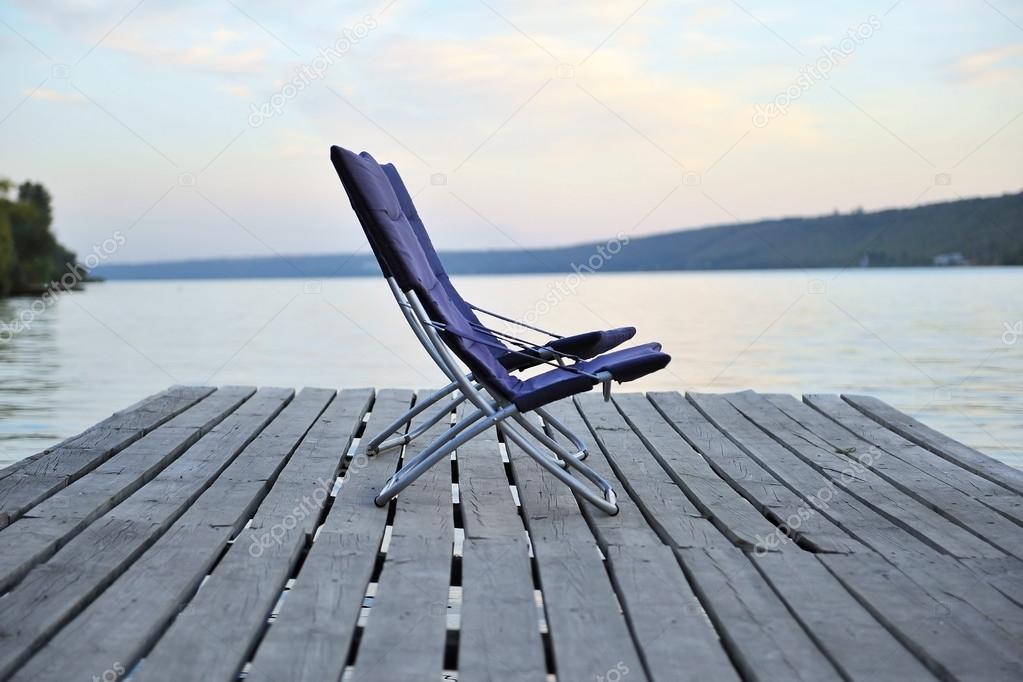 Two chairs on a wooden platform on the river