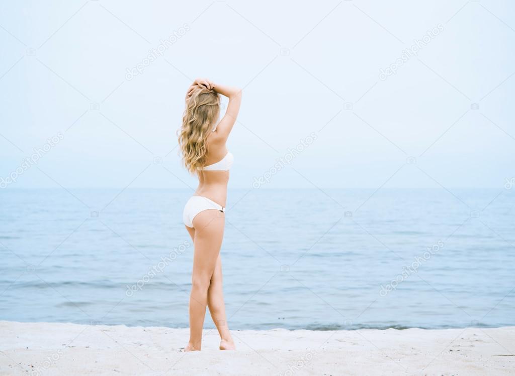 girl in white bikini posing on the beach