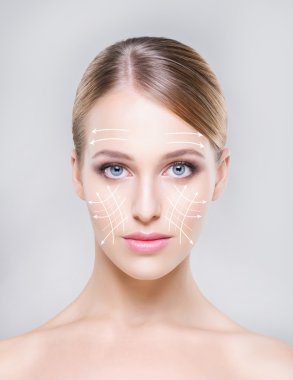 Gri bir arka plan üzerinde güzel ve genç kadın