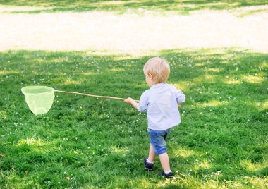 Küçük çocuk kepçe ile kelebekler yakalamak