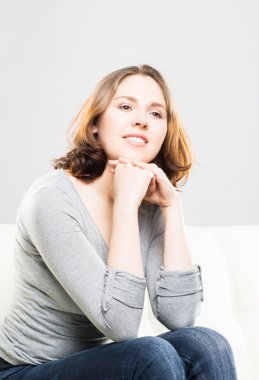 Genç ve çekici kız evde kanepede oturan