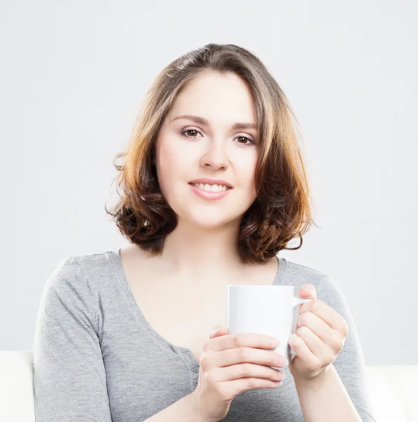 Menina atraente desfrutando de uma xícara de café em casa — Fotografia de Stock