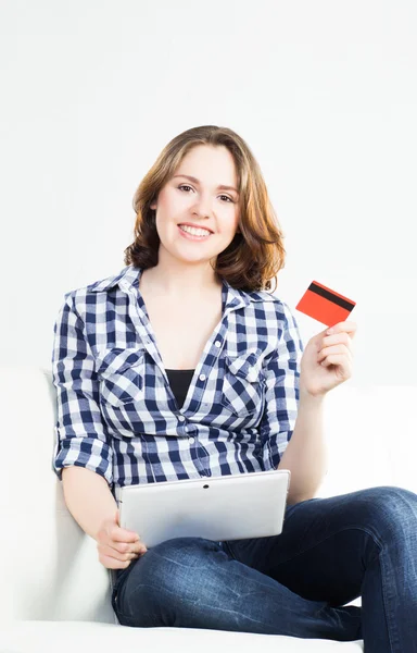 Attractive brunette woman with a credit card and a tablet computer — Stock Photo, Image