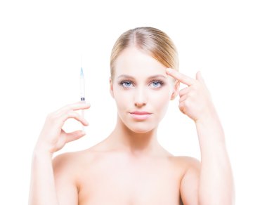 Young woman holding a syringe in her hands and injecting botox