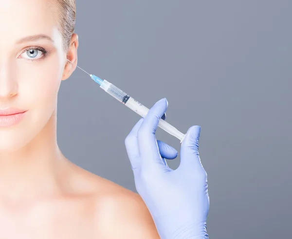 Dottore iniettando botox in un bel viso di una giovane donna — Foto Stock