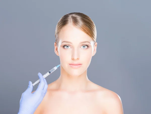 Doctor injecting botox in a beautiful face of a young woman — Stock Photo, Image