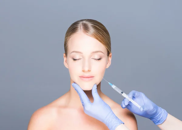 Doktor genç bir kadının güzel yüzüne botoks enjekte — Stok fotoğraf