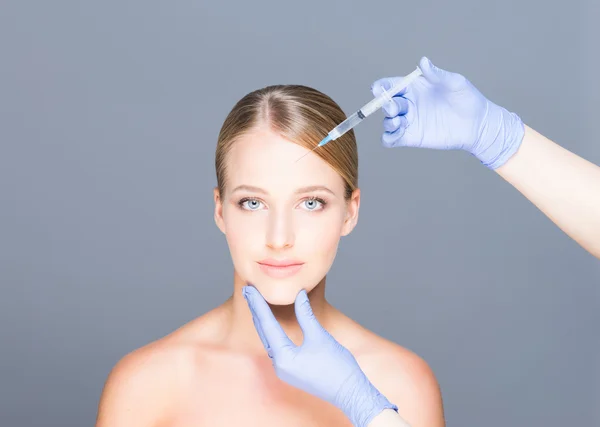 Doctor injecting botox in a beautiful face of a young woman — Stock Photo, Image