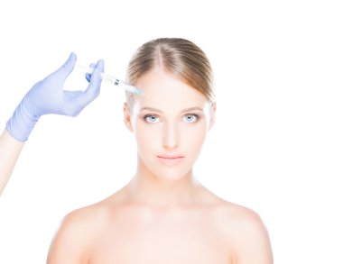 Bir kadının yüzüne botox enjekte eden doktor