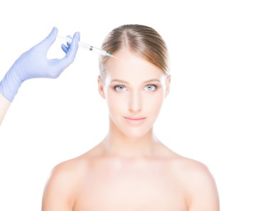 Bir kadının yüzüne botox enjekte eden doktor