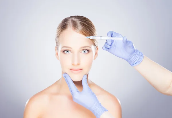 Läkare injicera botox i en kvinnas ansikte — Stockfoto