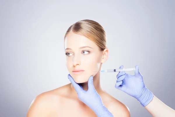 Läkare injicera botox i en kvinnas ansikte — Stockfoto