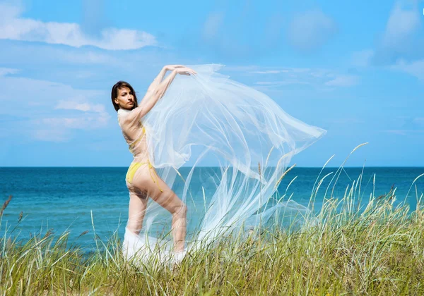 Jovem, mulher esportiva posando com seda soprando — Fotografia de Stock